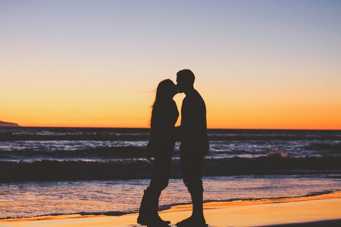 Couple kissing at sunset on the beach